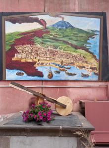 a painting and a clock on a wall with flowers at L'Alloggio dell'Artista in Belpasso