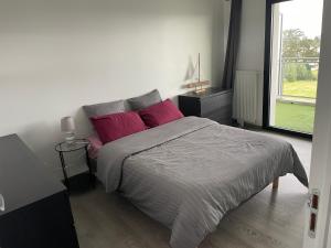 a bedroom with a bed with pink pillows and a window at appartement T2 Brest in Brest