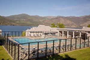 a swimming pool with chairs and a building and a lake at Wapato Point Resort in Manson