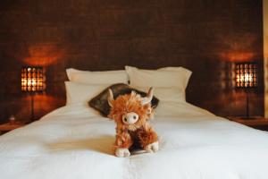 a stuffed animal is sitting on a bed at La Chamallow Vachement Douillet in Dinant