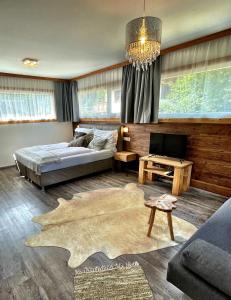 a bedroom with a bed and a tv and a couch at Chalet Maya in Schladming +56 photos