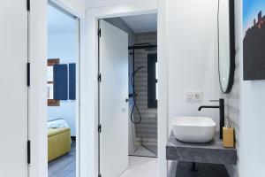 two views of a bathroom with a sink and a mirror at La Carrera 7 - Castillo - Parking sujeto a disponibilidad in Jaén +65 photos