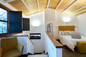 a bedroom with a bed and a chair and a window at La Carrera 7 - Castillo - Parking sujeto a disponibilidad in Jaén
