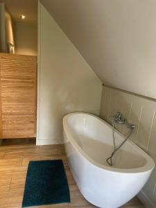 a white bath tub in a bathroom with a rug at B&B Het Merelnest in Waardamme
