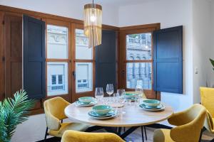 a dining room with a table and chairs and windows at La Carrera 7 - Castillo - Parking sujeto a disponibilidad in Jaén