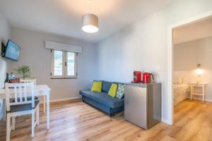Una sala de estar con un sofá azul y una mesa. en Casas das Hortas, Apartamento Vista Serra e Mar, en Seixal