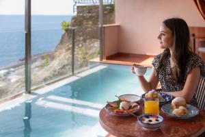 a woman sitting at a table with a bowl of food at Laqua by the Sea in Meta