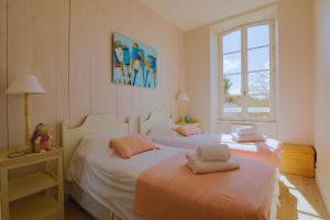 ein Schlafzimmer mit zwei Betten und einem Fenster in der Unterkunft Duplex joliment décoré et sa cour ensoleillée in Saint-Martin-de-Ré