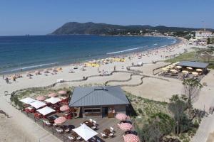 eine Luftansicht auf einen Strand mit Sonnenschirmen und Personen in der Unterkunft Appartement Le Rescator à Tamaris vue mer exceptionnelle climatisé résidence avec piscine et parking in La Seyne-sur-Mer