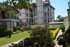 vistas a un edificio con un patio con arbustos en Parkview Safari Hotel & Apartments, en Kisumu