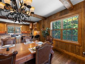 un comedor con una gran mesa de madera y una lámpara de araña en Snowed Inn - Meredith Lodging, en Government Camp