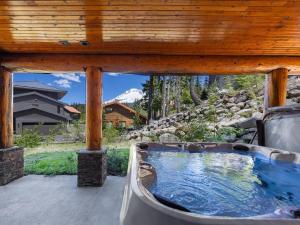 un patio con bañera de hidromasaje y techo de madera en Snowed Inn - Meredith Lodging, en Government Camp