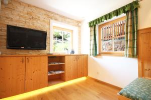 a living room with a television on a brick wall at Almliesl LOFE-727 in Lofer