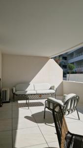 a patio with two chairs and a couch on a building at Archipel Coté Jardin in Valras-Plage