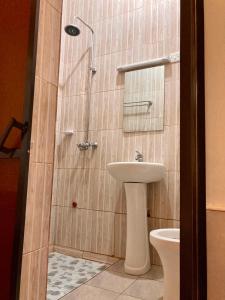 a bathroom with a shower with a sink and a toilet at WEST ORANGE LODGE in Moshi +51 photos