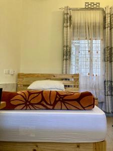 a bedroom with two beds and a window at WEST ORANGE LODGE in Moshi