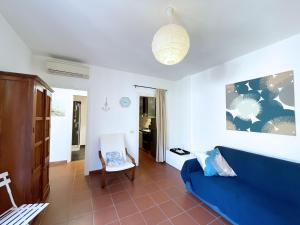 a living room with a blue couch and a chair at Sant'Anna Del Volterraio - Papaveri 7 in SantʼAnna