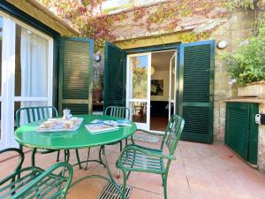 a green table and chairs on a patio at Sant'Anna Del Volterraio - Papaveri 7 in SantʼAnna