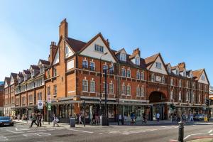 a large brick building on a busy city street at Spitalfields Sanctuary 2 Bed 2 Bath 100sqm Aprt in London