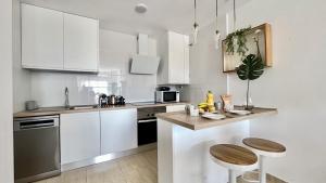 a kitchen with white cabinets and a counter top at Vicari Apartamento con Piscina by Gloove in El Campello