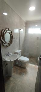 a bathroom with a sink and a toilet and a mirror at Hermosa casa amoblada in Barranquilla