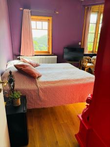 a bedroom with a bed with purple walls and a window at Ruime slaapkamers met badkamers in Belle Epoquevilla- concessiewijk De Haan in De Haan