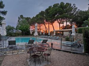 a table and chairs with umbrellas next to a pool at Mas de Fauchon - Teritoria in Saint-Cannat