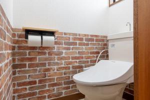 a bathroom with a toilet and a brick wall at 新大塚戸建て in Tokyo +30 photos