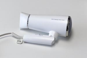 a white hair dryer with a cord plugged into it at 新大塚戸建て in Tokyo