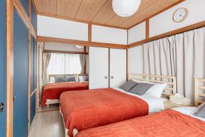 two beds in a room with blue walls at 新大塚戸建て in Tokyo