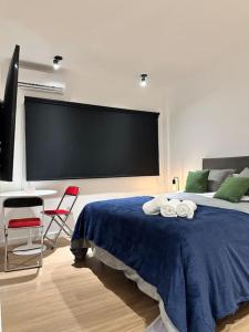 a bedroom with a bed with a large tv on the wall at Downtown Suite Self Check In in Buenos Aires