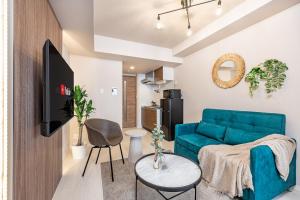 a living room with a blue couch and a table at FDS Serene in Osaka