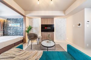 a bedroom with a bed and a table and a tv at FDS Serene in Osaka