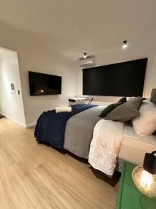 a bedroom with a large bed and a flat screen tv at Downtown Suite Self Check In in Buenos Aires
