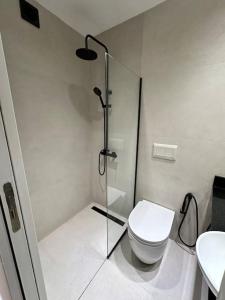 a bathroom with a toilet and a glass shower at Downtown Suite Self Check In in Buenos Aires