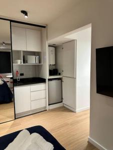 a kitchen with white cabinets and a black counter top at Downtown Suite Self Check In in Buenos Aires