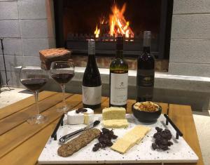 a table with two bottles of wine and two glasses at The Sinatra Holiday House in Mulwala - 10 individual beds in Mulwala