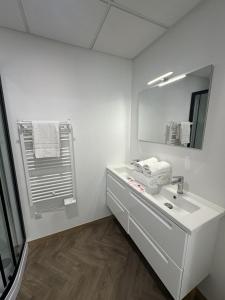 a white bathroom with a sink and a mirror at Studio familial du Cloitre in Narbonne +3 photos