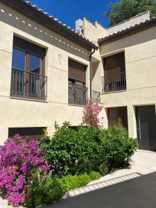 a building with windows and flowers in front of it at Dama Apartamentos Turísticos Toledo in Toledo