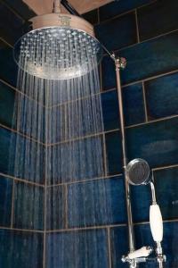 a shower with a shower head in a bathroom at Hyem at Cullercoats in Cullercoats