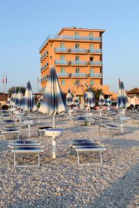 a group of tables and umbrellas in front of a building at Abbazia Club Hotel Marotta in Marotta