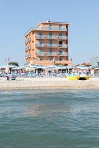 un hotel sulla spiaggia con un edificio sullo sfondo di Abbazia Club Hotel Marotta a Marotta