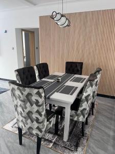 a dining room table with chairs and a black and white table at Staroot residency in Nairobi