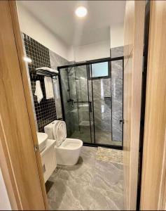 a bathroom with a toilet and a glass shower at Staroot residency in Nairobi