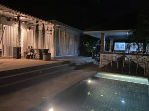 a house with a swimming pool at night at La maison du bonheur à samui in Koh Samui