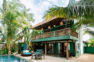 a green house with a balcony and a swimming pool at Salt Villa 3BR Beachfront An Bang Beach Hoi An by Beachside Boutique Homes in An Bang