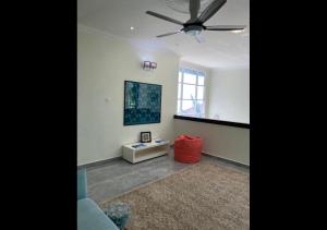 ein Wohnzimmer mit einem Deckenventilator und einem Sofa in der Unterkunft Che Beach House in Kampong Ru Sila