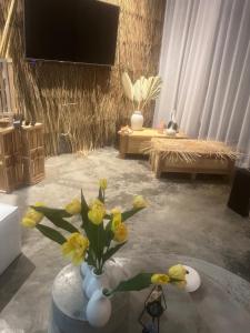 a room with a vase with yellow flowers in it at La maison du bonheur à samui in Koh Samui