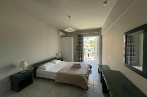 a bedroom with a bed and a large window at Mariannis Studios in Skala
