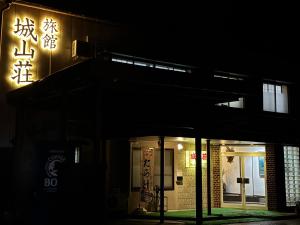 a building lit up at night with a sign on it at Shiroyamasou in Asahi